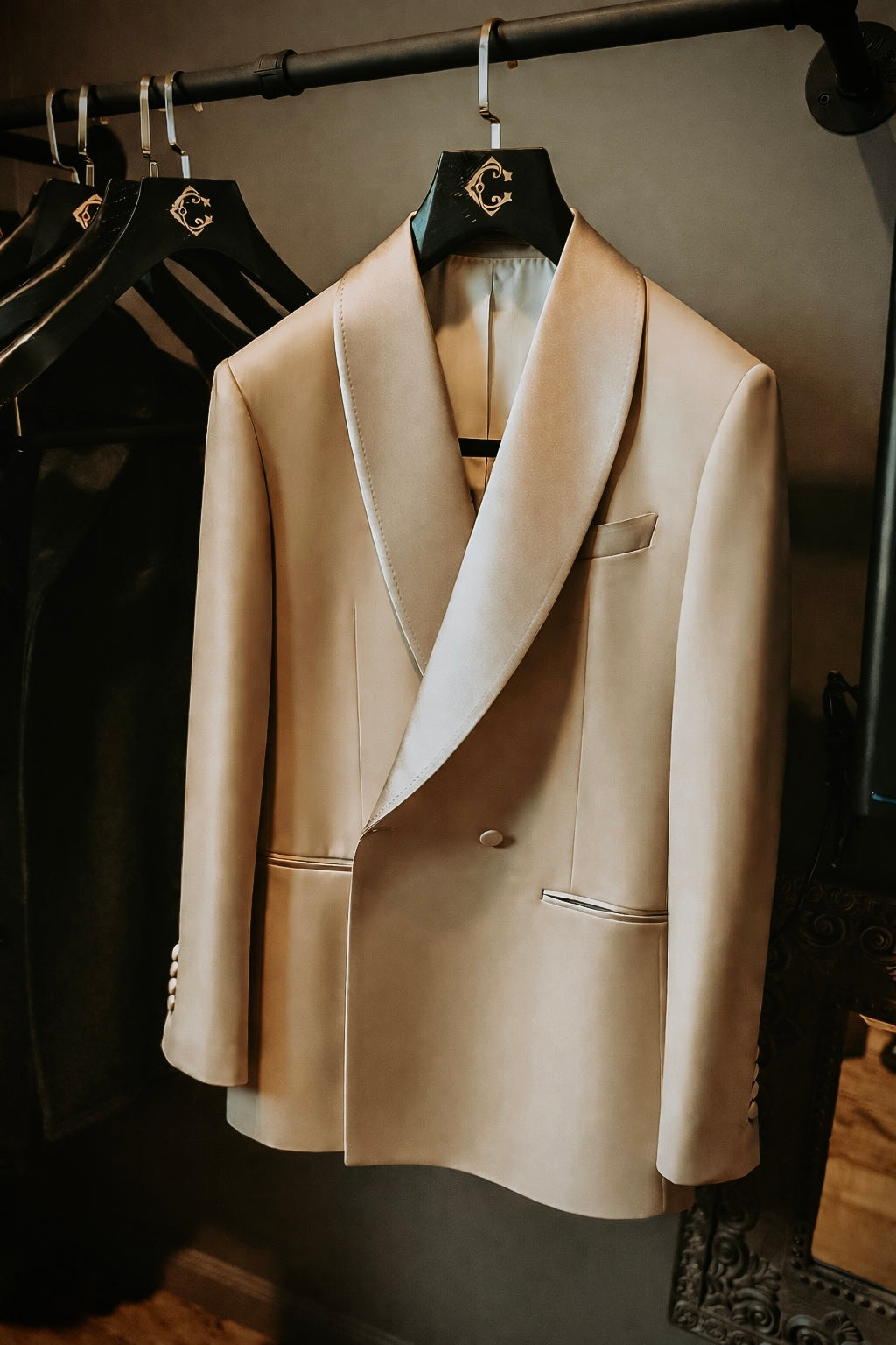 Beige blazer hanging on a rack with a neutral background